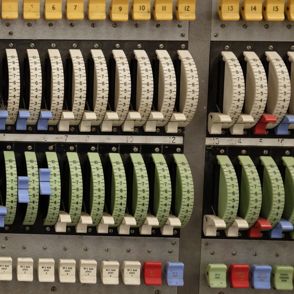 Close-up of a manual lighting desk with faders and switches