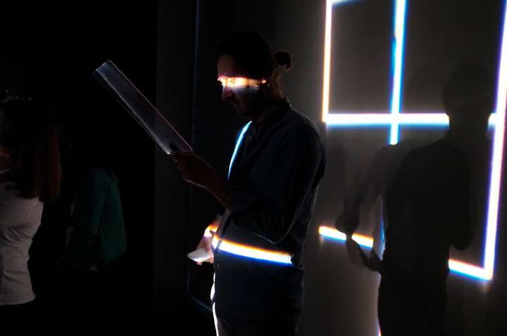 Person lit by a grid of narrow slits of light