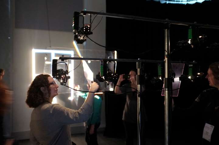 Grid of light on wall, with small luminaires on a stand in foreground