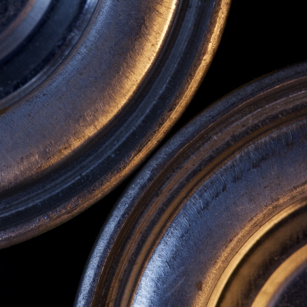 close up of part of two metal tins of paint from above, dramatically lit